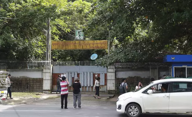 Journalists gather outside the residence of ousted leader Aung San Suu Kyi as the home is auctioned in Yangon, Myanmar Thursday, Aug. 15, 2024. (AP Photo/Thein Zaw)