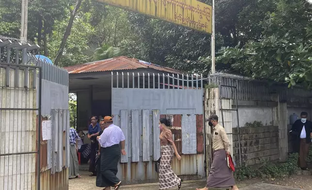 Unidentified legal officials from Kamayut district court walk into an entrance of the residence of ousted leader Aung San Suu Kyi as the home is auctioned in Yangon, Myanmar Thursday, Aug. 15, 2024. (AP Photo/Thein Zaw)