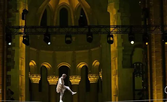 Philippe Petit walks a tightrope inside the Cathedral Church of St. John the Divine to mark the 50th anniversary of his World Trade Center Twin Towers high-wire walk, on Wednesday, Aug. 7, 2024, in New York. (Photo by Charles Sykes/Invision/AP)