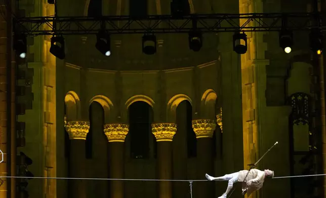 Philippe Petit lies on a tightrope inside the Cathedral Church of St. John the Divine to mark the 50th anniversary of his World Trade Center Twin Towers high-wire walk, on Wednesday, Aug. 7, 2024, in New York. (Photo by Charles Sykes/Invision/AP)