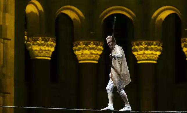 Philippe Petit walks a tightrope inside the Cathedral Church of St. John the Divine to mark the 50th anniversary of his World Trade Center Twin Towers high-wire walk, on Wednesday, Aug. 7, 2024, in New York. (Photo by Charles Sykes/Invision/AP)