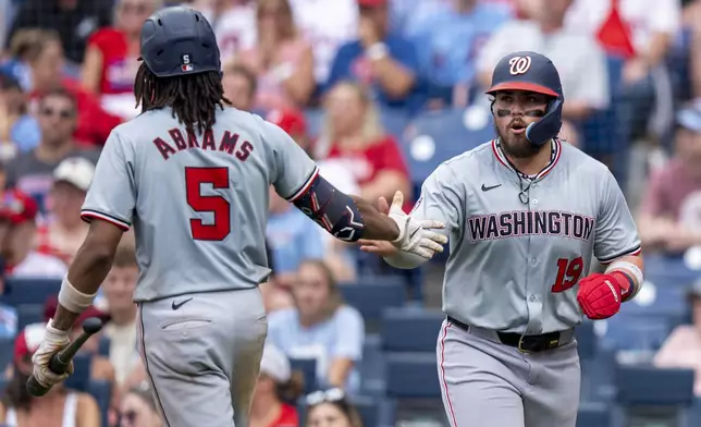 Washington Nationals' Andres Chaparro, right, celebrates his run with C.J. Abrams, left, during the eighth inning of a baseball game against the Philadelphia Phillies, Sunday, Aug. 18, 2024, in Philadelphia. (AP Photo/Chris Szagola)