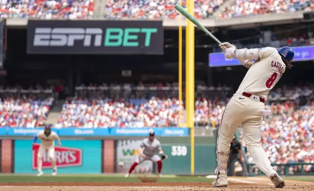 Philadelphia Phillies' Nick Castellanos hits a single to score Trea Turner during the first inning of a baseball game against the Washington Nationals, Sunday, Aug. 18, 2024, in Philadelphia. (AP Photo/Chris Szagola)