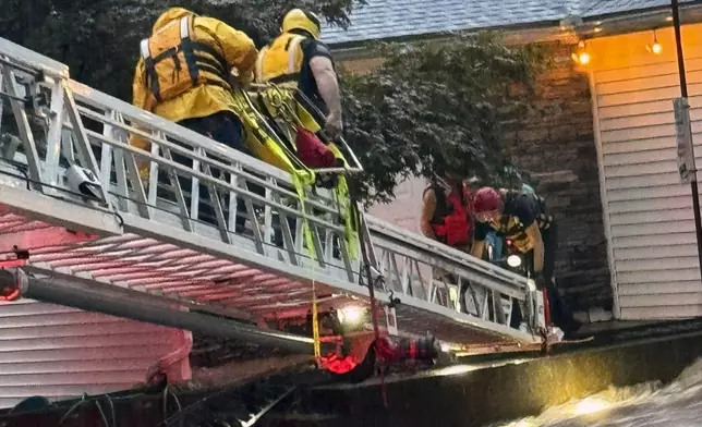 This photo provided by Beacon Hose Co. No. 1, a fire station in Beacon Falls, Connecticut, shows members of Beacon Hose Co. rescuing people from the Brookside Inn in Oxford, Conn., Sunday, Aug. 18, 2024. (Beacon Hose Co via AP)