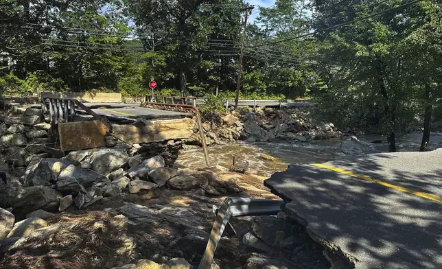 A bridge washed out on Seth Den Road in Oxford, Conn. after torrential rains turned streets into raging rivers in parts of Connecticut and New York's Long Island, trapping people in cars and a restaurant, covering vehicles in mud, and sweeping two women to their deaths, authorities said, Monday, Aug 19, 2024. (AP Photo Dave Collins)