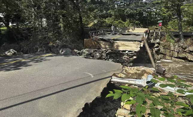 A bridge washed out on Seth Den Road in Oxford, Conn. after torrential rains turned streets into raging rivers in parts of Connecticut and New York's Long Island, trapping people in cars and a restaurant, covering vehicles in mud, and sweeping two women to their deaths, authorities said, Monday, Aug 19, 2024. (AP Photo Dave Collins)