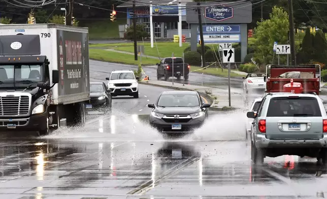 Vehicles pass through water on Newtown Rd. in Danbury, Conn., Monday, Aug. 19, 2024. (H John Voorhees III/Hearst Connecticut Media)