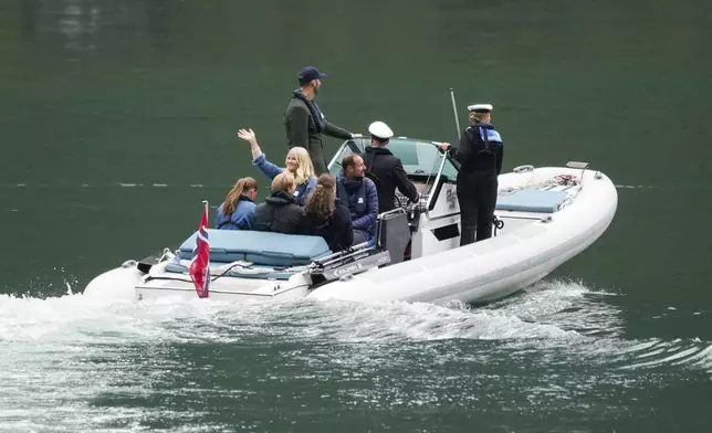 Norway's Crown Prince Haakon, 3rd right, Crown Princess Mette-Marit, center left waving, Princess Ingrid Alexandra, left, Prince Sverre Magnus, 2nd left, and Amalie Giaever MacLeod travel to Geiranger, Norway, Friday Aug. 30, 2024, ahead of the wedding celebration of Princess Martha Louise and Durek Verret on Saturday. (Cornelius Poppe/NTB via AP)