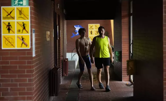 David Kratochvil, a teenage swimmer who prepares for the Paralympic Games in Paris, accompanied by his father Jiri arrives for his training in Tachov, Czech Republic, Wednesday, July 3, 2024. (AP Photo/Petr David Josek)