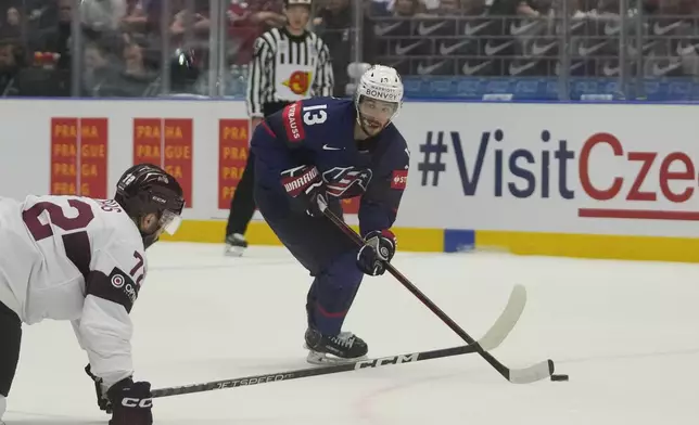 FILE - Unted States' Johnny Gaudreau, right, challenges for a puck with Latvia's Janis Jaks during the preliminary round match between Latvia and United States at the Ice Hockey World Championships in Ostrava, Czech Republic, Tuesday, May 21, 2024. (AP Photo/Darko Vojinovic, file)