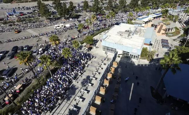 Fans line up to enter and get a bobblehead of Los Angeles Dodgers' Shohei Ohtani prior to a baseball game between the Dodgers and the Baltimore Orioles Thursday, Aug. 29, 2024, in Los Angeles. (AP Photo/Mark J. Terrill)