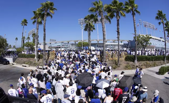 Fans line up to enter and get a bobblehead of Los Angeles Dodgers' Shohei Ohtani prior to a baseball game between the Dodgers and the Baltimore Orioles Thursday, Aug. 29, 2024, in Los Angeles. (AP Photo/Mark J. Terrill)