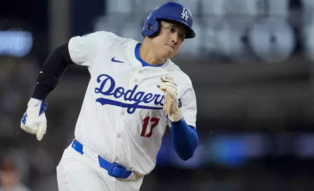 Los Angeles Dodgers' Shohei Ohtani runs rounds third base to score on a single from Teoscar Hernández during the third inning of a baseball game against the Baltimore Orioles, Tuesday, Aug. 27, 2024, in Los Angeles. (AP Photo/Marcio Jose Sanchez)