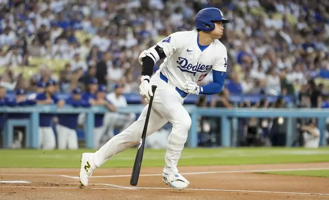 Los Angeles Dodgers' Shohei Ohtani follows through on a single during the first inning of a baseball game against the Baltimore Orioles, Tuesday, Aug. 27, 2024, in Los Angeles. (AP Photo/Marcio Jose Sanchez)