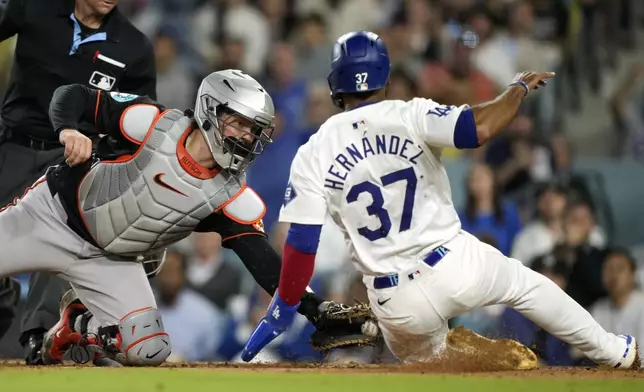 Los Angeles Dodgers' Teoscar Hernández, right, is tagged out by Baltimore Orioles catcher Adley Rutschman as he tries to score on a single by Miguel Rojas during the fourth inning of a baseball game Thursday, Aug. 29, 2024, in Los Angeles. (AP Photo/Mark J. Terrill)