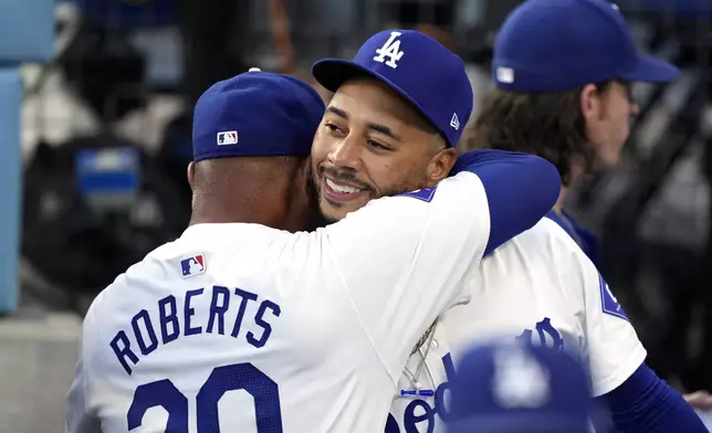 Los Angeles Dodgers' Mookie Betts, right, gets a hug from manager Dave Roberts prior to a baseball game against the Baltimore Orioles Thursday, Aug. 29, 2024, in Los Angeles. (AP Photo/Mark J. Terrill)