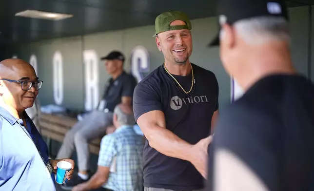 Retired Major League Baseball player Matt Holliday greets Colorado Rockies manager Bud Black before the Baltimore Orioles face the Rockies in a baseball game, Friday, Aug. 30, 2024, in Denver. (AP Photo/David Zalubowski)