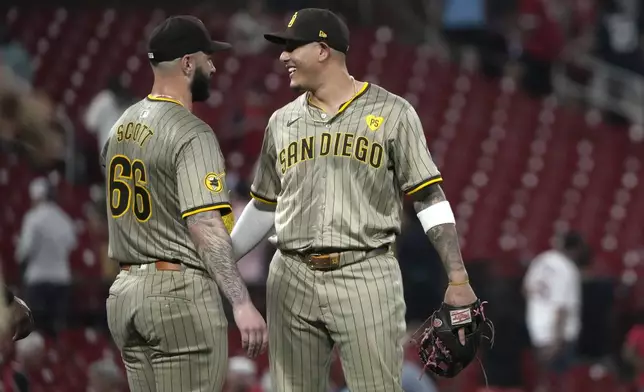 San Diego Padres Tanner Scott and teammate Manny Machado celebrate a 7-5 victory over the St. Louis Cardinals in a baseball game Tuesday, Aug. 27, 2024, in St. Louis. (AP Photo/Jeff Roberson)