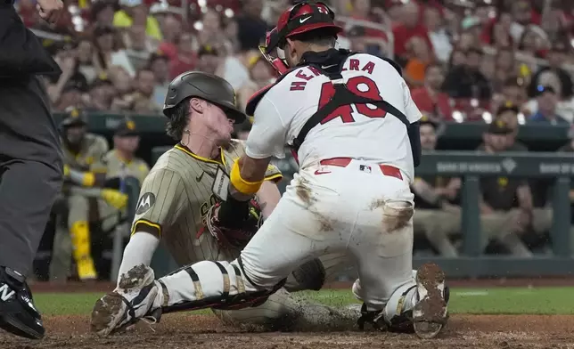 aSan Diego Padres' Bryce Johnson, left, is tagged out at home by St. Louis Cardinals catcher Ivan Herrera during the eighth inning of a baseball game Monday, Aug. 26, 2024, in St. Louis. (AP Photo/Jeff Roberson)