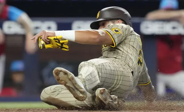 San Diego Padres' David Peralta scores on a single hit by Ha-Seong Kim during the fourth inning of a baseball game against the Miami Marlins, Saturday, Aug. 10, 2024, in Miami. (AP Photo/Lynne Sladky)