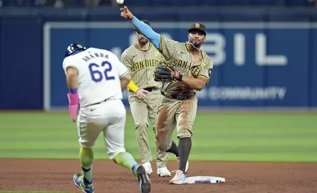 San Diego Padres second baseman Xander Bogaerts forces Tampa Bay Rays' Jonathan Aranda (62) at second base and turns a double play on Junior Caminero during the fourth inning of a baseball game Friday, Aug. 30, 2024, in St. Petersburg, Fla. (AP Photo/Chris O'Meara)