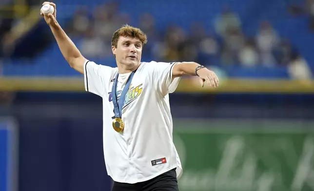 2024 Olympic swimming gold and silver medalist Bobby Finke throws out the ceremonial first pitch before a baseball game between the Tampa Bay Rays and the San Diego Padres Friday, Aug. 30, 2024, in St. Petersburg, Fla. (AP Photo/Chris O'Meara)