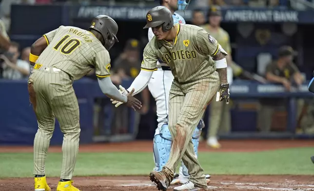 San Diego Padres' Manny Machado, right, celebrates with Jurickson Profar (10) after Machado hit a three-run home run off Tampa Bay Rays starting pitcher Taj Bradley during the second inning of a baseball game Friday, Aug. 30, 2024, in St. Petersburg, Fla. (AP Photo/Chris O'Meara)