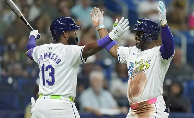 Tampa Bay Rays' Yandy Diaz celebrates his home run off San Diego Padres starting pitcher Martin Perez with on-deck batter Junior Caminero (13) during the second inning of a baseball game Friday, Aug. 30, 2024, in St. Petersburg, Fla. (AP Photo/Chris O'Meara)