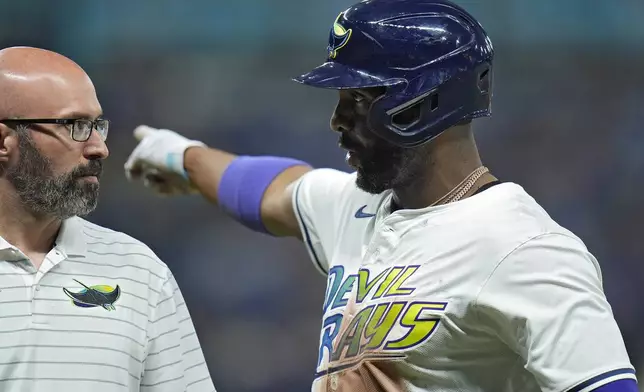 Tampa Bay Rays' Yandy Diaz talks to trainer Joe Benge after leaving the game with an injury during the fourth inning of a baseball game against the San Diego Padres Friday, Aug. 30, 2024, in St. Petersburg, Fla. (AP Photo/Chris O'Meara)