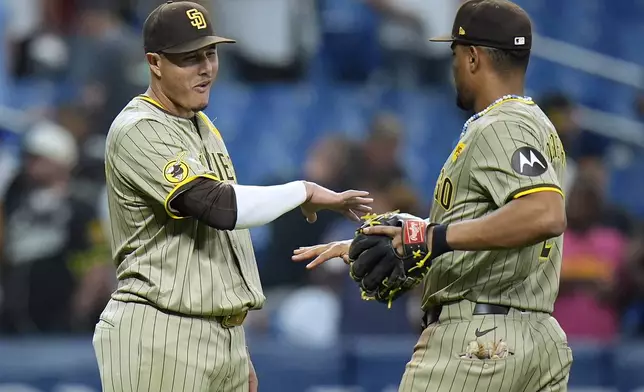 San Diego Padres' Manny Machado, left, celebrates with Xander Bogaerts after the team defeated the Tampa Bay Rays during a baseball game Friday, Aug. 30, 2024, in St. Petersburg, Fla. (AP Photo/Chris O'Meara)