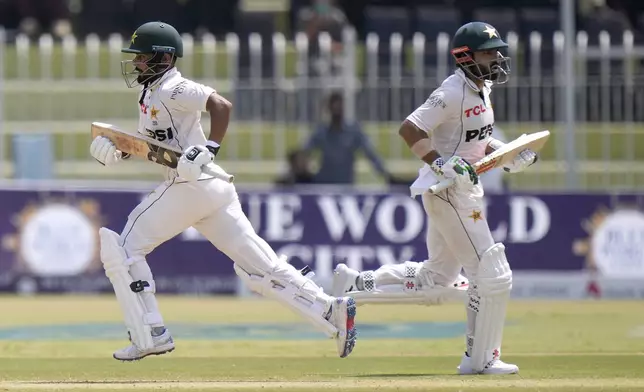 Pakistan's Mohammad Rizwan, right, and Saud Shakeel run between the wickets during the second day of first cricket test match between Pakistan and Bangladesh, in Rawalpindi, Pakistan, Thursday, Aug. 22, 2024. (AP Photo/Anjum Naveed)