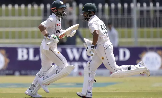 Pakistan's Mohammad Rizwan, left, and Saud Shakeel run between the wickets during the second day of first cricket test match between Pakistan and Bangladesh, in Rawalpindi, Pakistan, Thursday, Aug. 22, 2024. (AP Photo/Anjum Naveed)