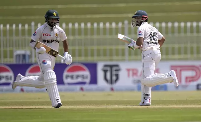 Pakistan's Mohammad Rizwan, right, and Saud Shakeel run between the wickets during the second day of first cricket test match between Pakistan and Bangladesh, in Rawalpindi, Pakistan, Thursday, Aug. 22, 2024. (AP Photo/Anjum Naveed)