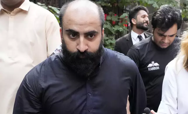 Farhan Asif, a freelance web developer who was arrested and charged with cyber terrorism for his alleged role in spreading misinformation that led to widespread rioting in the U.K. earlier this month, leaves with officials after his court appearance, in Lahore, Pakistan, Monday, Aug. 26, 2024. (AP Photo/K.M. Chaudary)