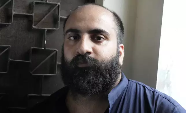 Farhan Asif, center, a freelance web developer who was arrested and charged with cyber terrorism for his alleged role in spreading misinformation that led to widespread rioting in the U.K. earlier this month, waits for his court appearance, in Lahore, Pakistan, Thursday, Aug. 22, 2024. (AP Photo/K.M. Chaudary)