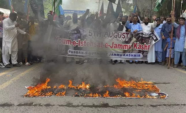 Supporters Pasban-e-Hurriyat Jammu Kashmir burn portraits of Indian Prime Minister Narendra Modi, and other officials during a protest to show solidarity with the Kashmiri people on the eve of the fifth anniversary of India's decision to strip the disputed region of its semi-autonomy, in Muzaffarabad, the capital of Pakistani Kashmir, Monday, Aug. 5, 2024. (AP Photo/M.D. Mughal)