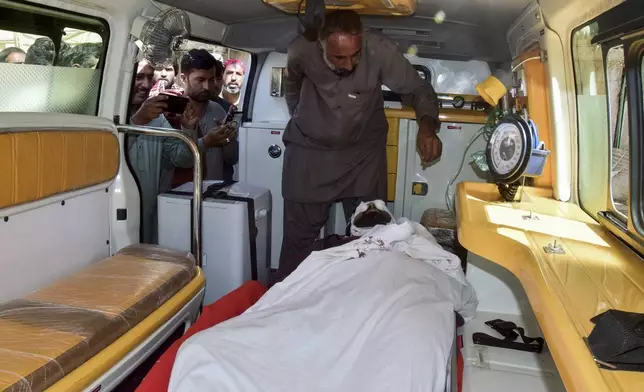 Relatives look at the body of passenger, killed by gunmen at a highway in Musakhail, inside an ambulance after collecting it from a hospital, in Quetta, Pakistan, Monday, Aug. 26, 2024. (AP Photo/Arshad Butt)