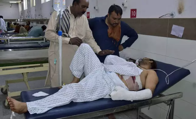 Relatives take care of a passenger, wounded by gunmen at a highway in Musakhail, after receiving initial treatment at a hospital, in Quetta, Pakistan, Monday, Aug. 26, 2024. (AP Photo/Arshad Butt)