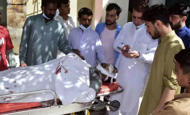 Relatives gather around a body of a passenger, killed by gunmen at a highway in Musakhail, as they wait for transportation at a hospital, in Quetta, Pakistan, Monday, Aug. 26, 2024. (AP Photo/Arshad Butt)