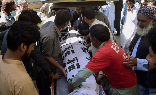 Volunteers and relatives load the body of a passenger, who was killed by gunmen at a highway in Musakhail, into a vehicle after collecting it from a hospital, in Quetta, Pakistan, Monday, Aug. 26, 2024. (AP Photo/Arshad Butt)