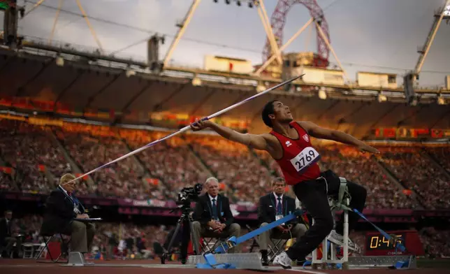 In light from the setting sun, Tunisia's Mohamed Ali Krid makes a throw in the men's javelin F34 category event during the athletics competition at the 2012 Paralympics, Sept. 1, 2012, in London. (AP Photo/Matt Dunham)