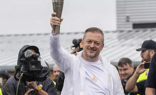 International Paralympic Committee (IPC) President Andrew Parsons holds up the Paralympic Torch during the flame lighting ceremony in Stoke Mandeville, widely considered the birthplace of the Paralympic Games, England, Saturday, Aug. 24, 2024. (AP Photo/Thomas Krych)