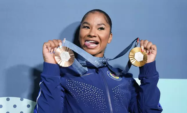 Jordan Chiles, of the United States, holds up her medals after the women's artistic gymnastics individual apparatus finals Bercy Arena at the 2024 Summer Olympics, Monday, Aug. 5, 2024, in Paris, France. (AP Photo/Charlie Riedel)