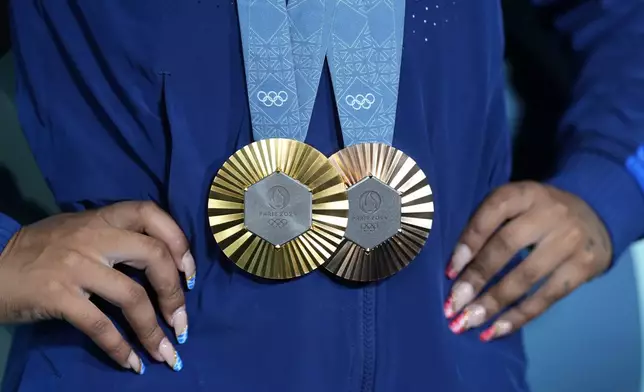 Jordan Chiles, of the United States, holds up her medals after the women's artistic gymnastics individual apparatus finals Bercy Arena at the 2024 Summer Olympics, Monday, Aug. 5, 2024, in Paris, France. (AP Photo/Charlie Riedel)