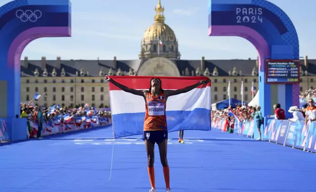 Sifan Hassan, of the Netherlands, celebrates after crossing the finish line to win the gold medal at the end of the women's marathon competition at the 2024 Summer Olympics, Sunday, Aug. 11, 2024, in Paris, France. (AP Photo/Vadim Ghirda)