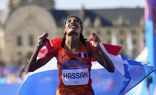 Sifan Hassan, of the Netherlands, celebrates after crossing the finish line to win the gold medal at the end of the women's marathon competition at the 2024 Summer Olympics, Sunday, Aug. 11, 2024, in Paris, France. (AP Photo/Vadim Ghirda)