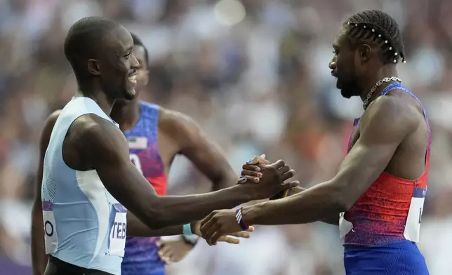 Gold medalist Letsile Tebogo, of Botswana, and bronze medalist Noah Lyles, of the United States, right, shake hands after finishing the men's 200 meters final at the 2024 Summer Olympics, Thursday, Aug. 8, 2024, in Saint-Denis, France. (AP Photo/Ashley Landis)