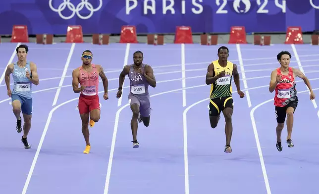 Chun-Han Yang, of Taiwan, Andre de Grasse, of Canada, Noah Lyles, of the United States, Bryan Levell, of Jamaica, and Towa Uzawa, of Japan, run in a men's 200 meters round 1 heat at the 2024 Summer Olympics, Monday, Aug. 5, 2024, in Saint-Denis, France. (AP Photo/Martin Meissner)