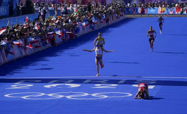 Dakotah Lindwurm, of the United States, celebrates after crossing the finish line at the end of the women's marathon competition at the 2024 Summer Olympics, Sunday, Aug. 11, 2024, in Paris, France. (AP Photo/Dar Yasin)