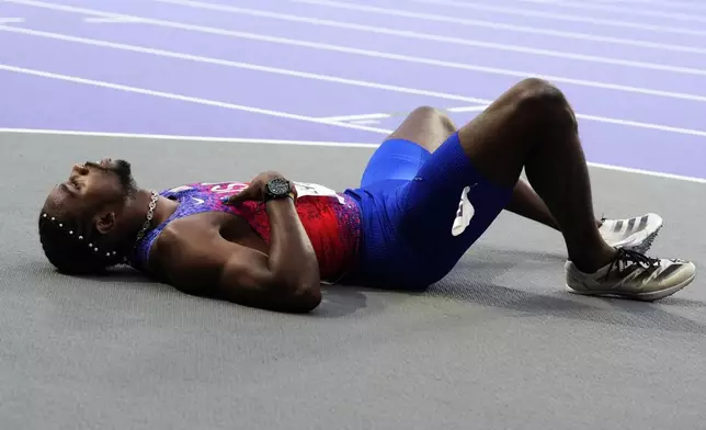 Noah Lyles, of the United States, lies on the track following the men's 200-meters final at the 2024 Summer Olympics, Thursday, Aug. 8, 2024, in Saint-Denis, France. (AP Photo/Petr David Josek)